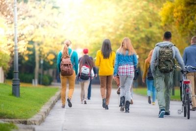 Various students walking on a path outside
