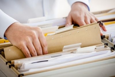 A close up of a file being pulled from a drawer.