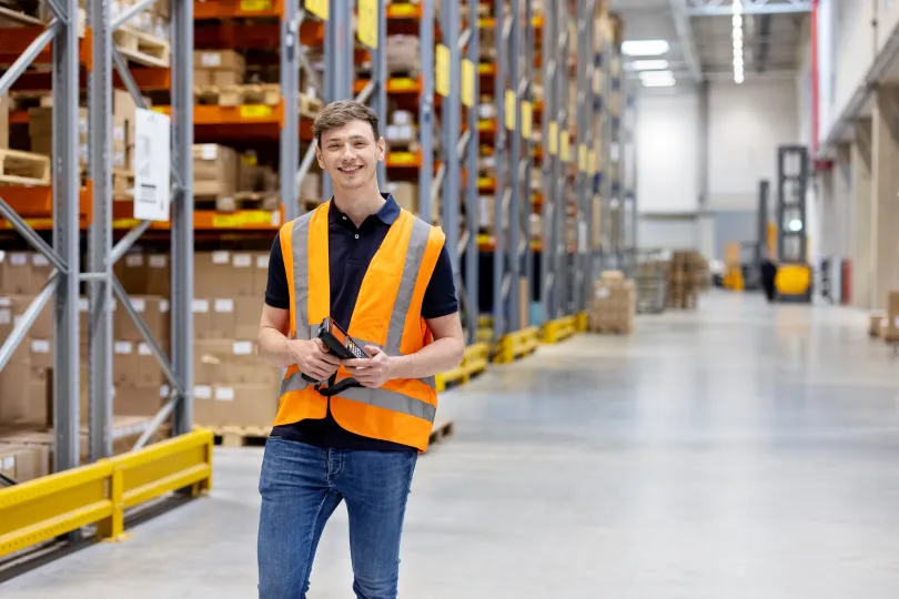 Portrait of a confident young worker with bar code reader in a distribution warehouse