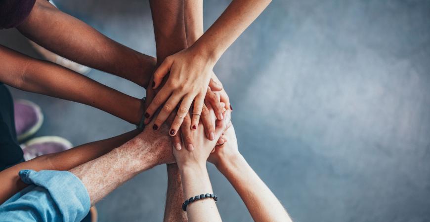 Several individuals grasping hands together