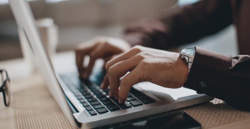 Student typing on a laptop