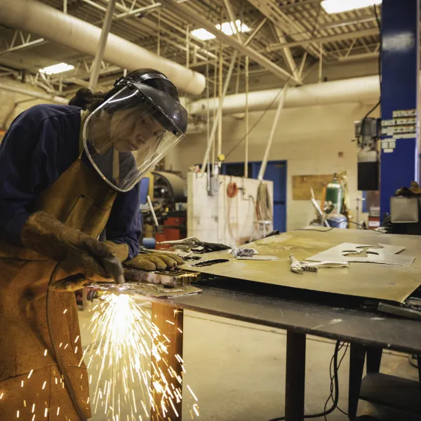 female apprentice practicing her welding skills