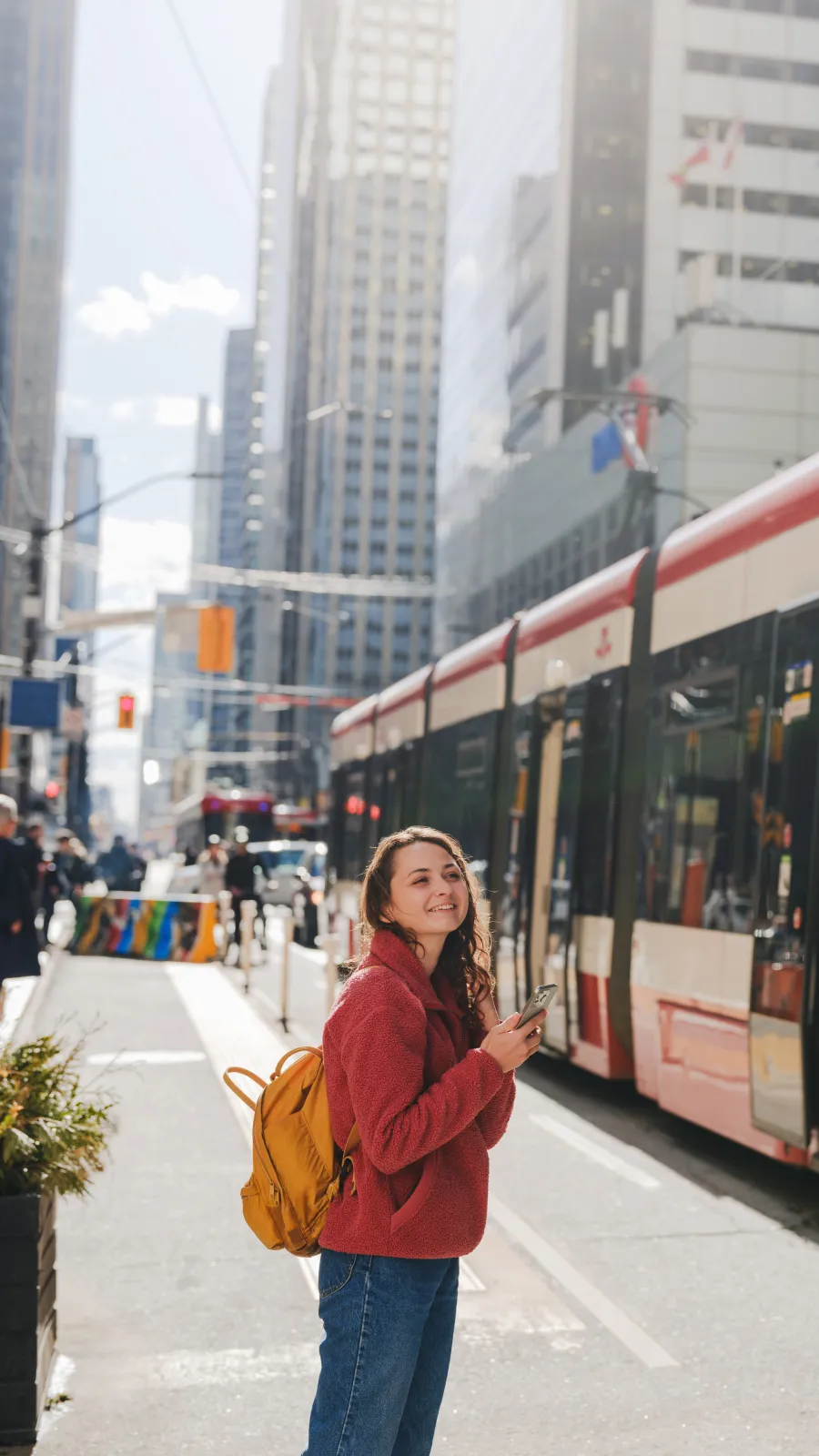 Woman using smartphone waiting for the street car in Toronto, Ontario