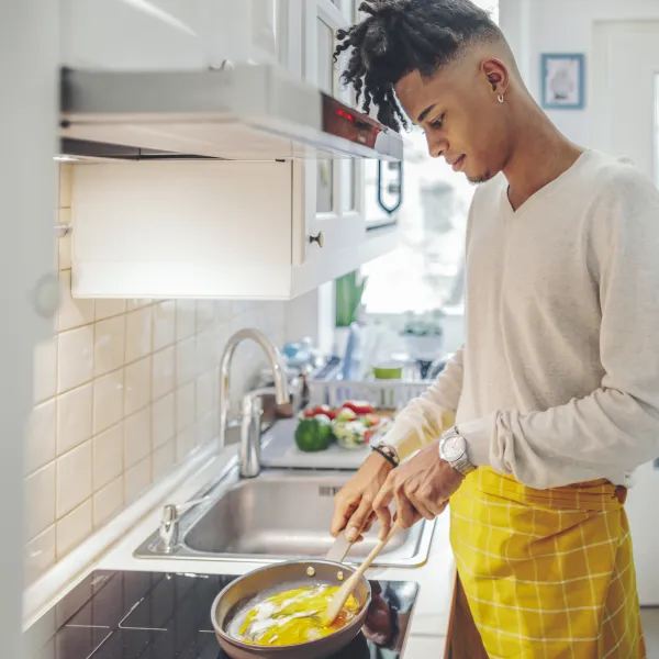 Young adult male in the kitchen cooking