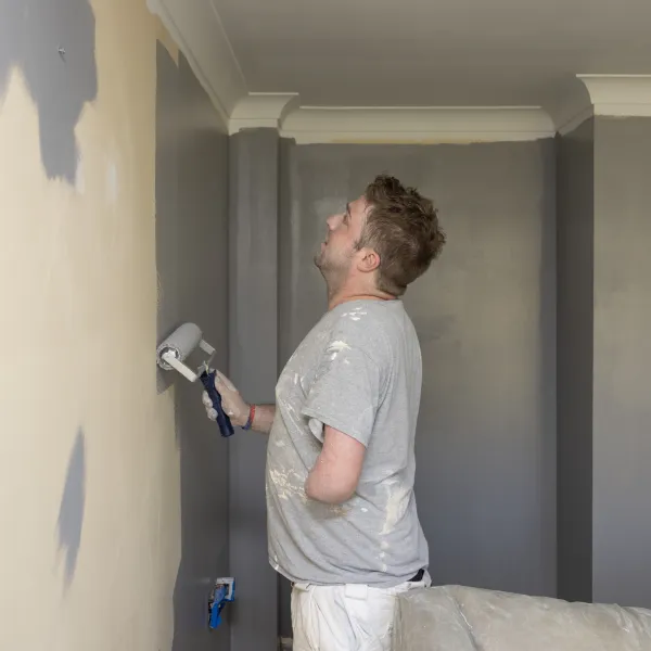 Young skilled painter, painting a domestic living room