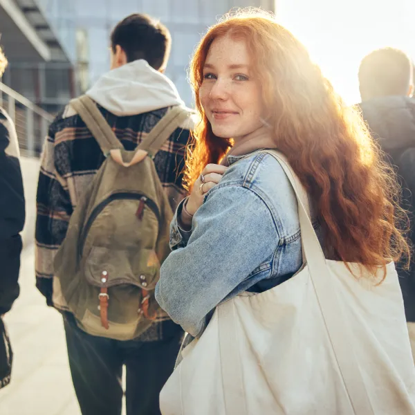 male student glancing back while going for a class in college