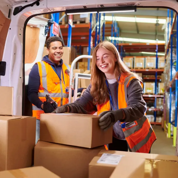 young warehosue workers loading a van