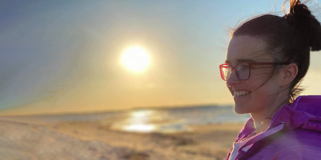 Kailha debout à la plage devant un couchez du soleil