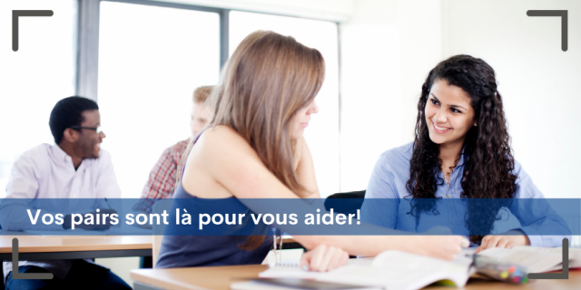 2 étudiants qui parlent et travaillent ensemble assis à un pupitre